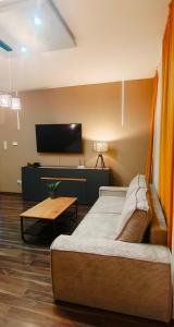a bedroom with a bed and a table and a tv at Mieszkanie z Ogrodem in Kluczbork