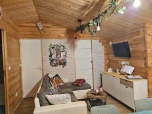 a living room with a couch and a desk at Chalet près du lac in Les Mazures