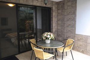 a patio table with chairs and a vase of flowers at The White Houses 7 in Nesebar