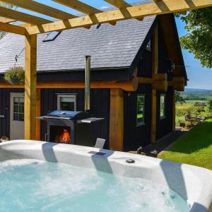 a house with a fireplace in front of it at Rowanlea Lodge Hot Tub Secure Garden Pub 5 min walk in Laurencekirk