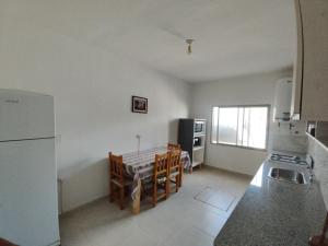 a kitchen with a refrigerator and a table and chairs at Hostal La Candelaria in Humahuaca +8 photos