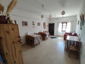 a living room with tables and chairs in a house at Hostal La Candelaria in Humahuaca
