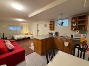 a kitchen and a living room with a red couch at Lovely suite in Burnaby