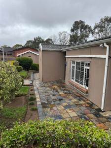 a house with a stone walkway in front of it at Virginia Town House in Mthatha