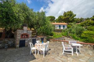 a patio with a table and chairs and a fireplace at Villa Ciacia in Cervo