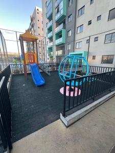 a playground with a slide and a play structure at Apto vista in Ponta Grossa