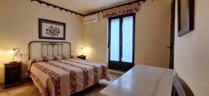 a bedroom with a bed and a large window at La Casa del Regidor Hotel Rural Fermoselle in Fermoselle
