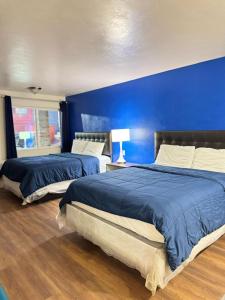 two beds in a bedroom with a blue wall at Alien Residence Inn in Pecos +27 photos