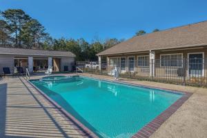 a swimming pool in front of a house at SureStay Hotel by Best Western Leesville in Leesville