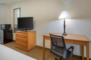 a room with a desk with a television and a chair at SureStay Hotel by Best Western Leesville in Leesville