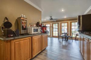 a kitchen with a counter with a microwave and a table at SureStay Hotel by Best Western Leesville in Leesville