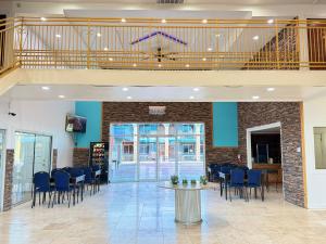 a lobby with chairs and a table and a staircase at Alien Residence Inn in Pecos
