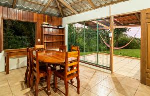 a dining room with a table and chairs and a large window at Corcovado Green Cabin & House in Drake
