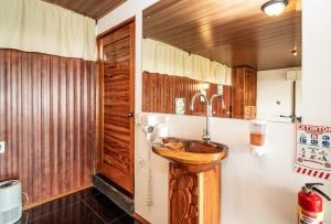 a bathroom with a wooden sink on the wall at Corcovado Green Cabin & House in Drake