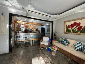 a living room with a couch and a bar at Skalla Hotel Nova Odessa in Nova Odessa