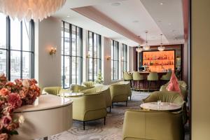 a restaurant with tables and chairs and windows at Hotel Port-Royal in Quebec City