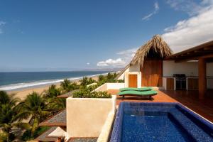 a villa with a swimming pool next to the beach at Stunning, Oceanfront Casa de Olas in Ixtapa-Zihuatanejo International