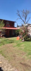 a house with a yard with grass and a tree at Posada "Villa Biker" in Villa del Carbón