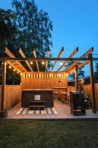 a backyard with a fire pit and a wooden pergola at Rowanlea Lodge Hot Tub Secure Garden Pub 5 min walk in Laurencekirk