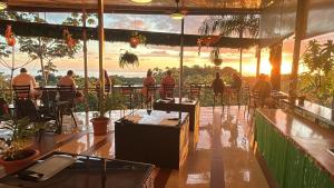 a group of people sitting at tables in a restaurant at Mountain Top Park Hotel in Manuel Antonio