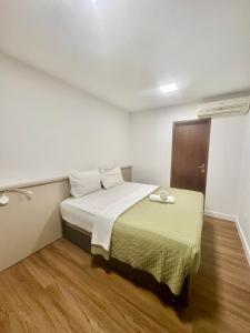 a bedroom with a bed in a white room at Hotel Natur Campeche in Florianópolis