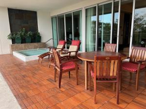 a patio with a table and chairs and a pool at luxury 2bed condo in Nuevo Vallarta +2 photos