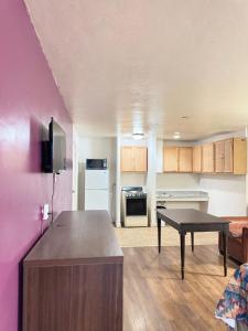 a living room with a table and a kitchen at Alien Residence Inn in Pecos