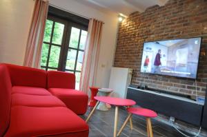 sala de estar con sofá rojo y TV en Holiday Home Poppenhuis, en Durbuy