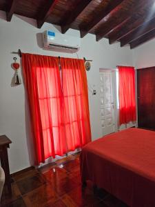 a bedroom with red curtains and a red bed at Posada Oporto in La Rioja