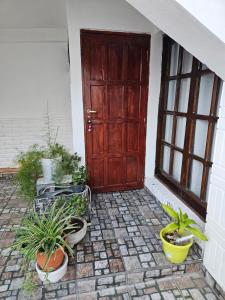 a wooden door with potted plants on a patio at Posada Oporto in La Rioja