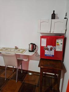 a small kitchen with a table and a red refrigerator at Posada Oporto in La Rioja +1 photo