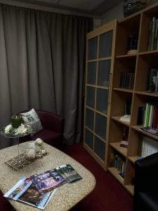 a living room with a table and a book shelf at Weigands Hotel Peter in Reinhardshagen