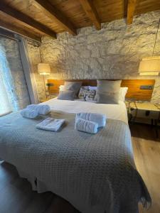 a bedroom with a large bed with towels on it at La Casa del Cantero in Pinilla del Valle