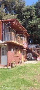 a large brick house with a balcony and a deck at Posada "Villa Biker" in Villa del Carbón