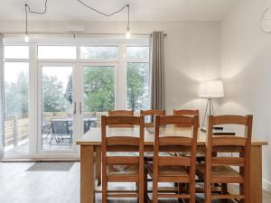 a dining room with a wooden table and chairs at The Barn-Uk32860 in Neath