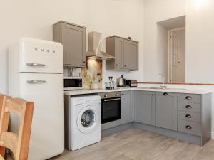 a kitchen with a washing machine and a washer at The Barn-Uk32860 in Neath +15 photos