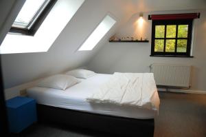 a bedroom with a white bed in a attic at Holiday Home Poppenhuis in Durbuy