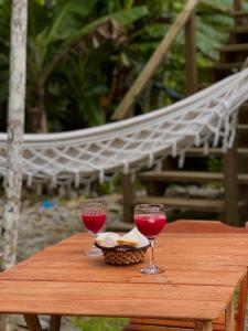 two glasses of red wine sitting on a wooden table at Morada do Sol Petar in Iporanga