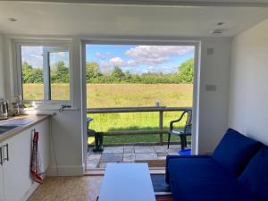 a kitchen and living room with a view of a field at April Cottage Meadow Studio in Mere