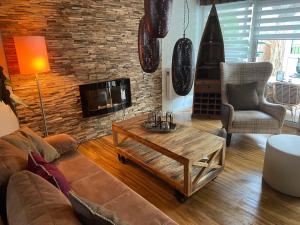 a living room with a couch and a coffee table at Sehr schöne ufernahe ebenerdige Ferienwohnung Pura Vida auf der Halbinsel Scheid in Scheid