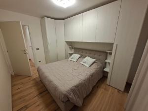a small bedroom with a bed and white cabinets at La cà de Clüsu in Clusone