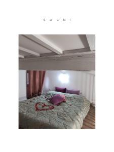 a bed with purple pillows on it in a room at Mariposa in Capodimonte