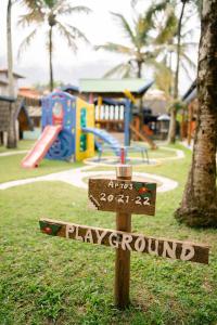 a sign in a park with a playground in the background at Hotel Pousada Tambayba in Maresias +79 photos