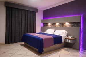a bedroom with a bed with purple lights on it at Autohotel Punto de Descanso Cordoba in Córdoba