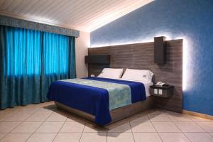 a bedroom with a bed with blue walls and blue curtains at Autohotel Punto de Descanso Cordoba in Córdoba +5 photos