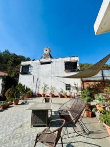 a patio with chairs and a table and a building at Casa ELA Candelaria in Antigua Guatemala