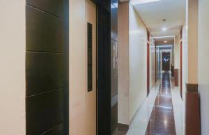a hallway with black doors and a long corridor at Hotel O Span Executive in Pune