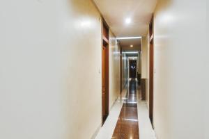a hallway with white walls and a long corridor at Hotel O Span Executive in Pune