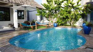 a swimming pool in front of a house at Palm Residence Vacation Villa in Nungwi