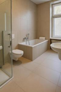 a bathroom with a tub and a toilet and a sink at NEU im Zentrum stilvolle Premium-Suite mit Parkplatz in Gummersbach +8 photos